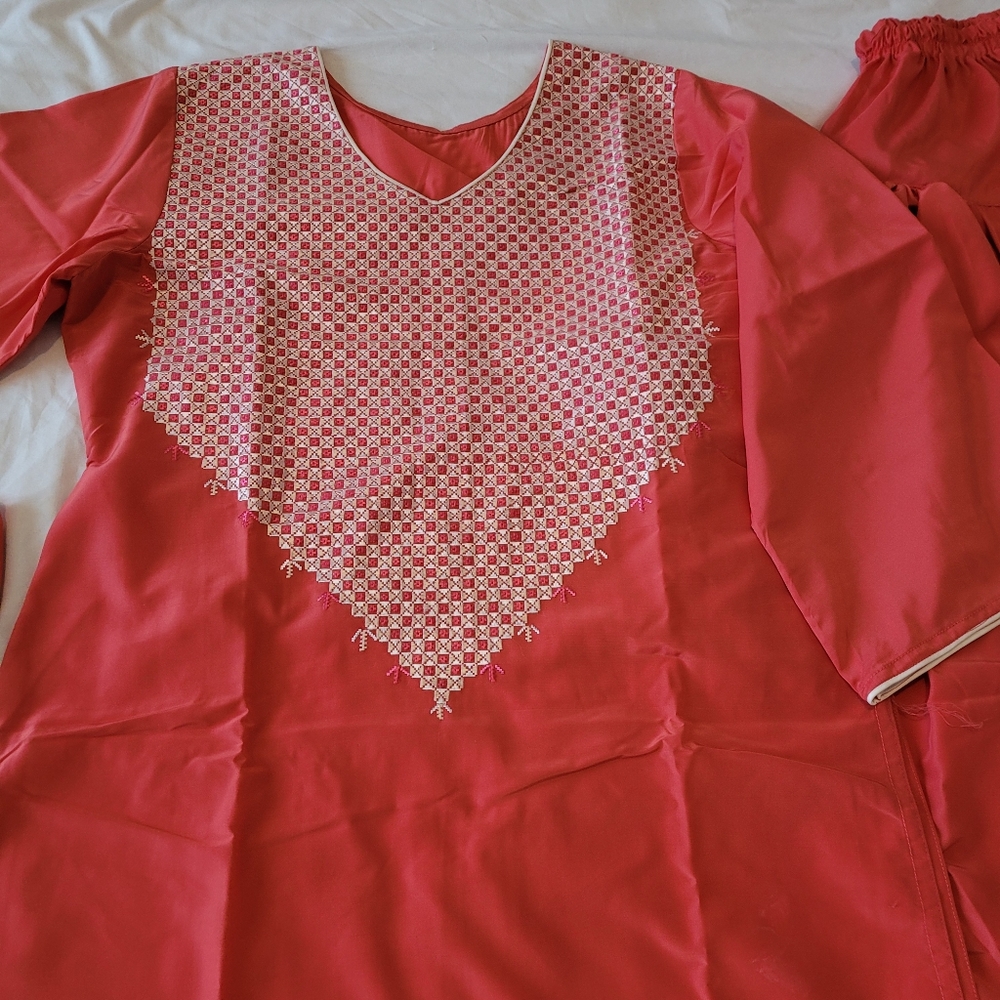 A woman already made clothes with hand made embroidery work on the dress.